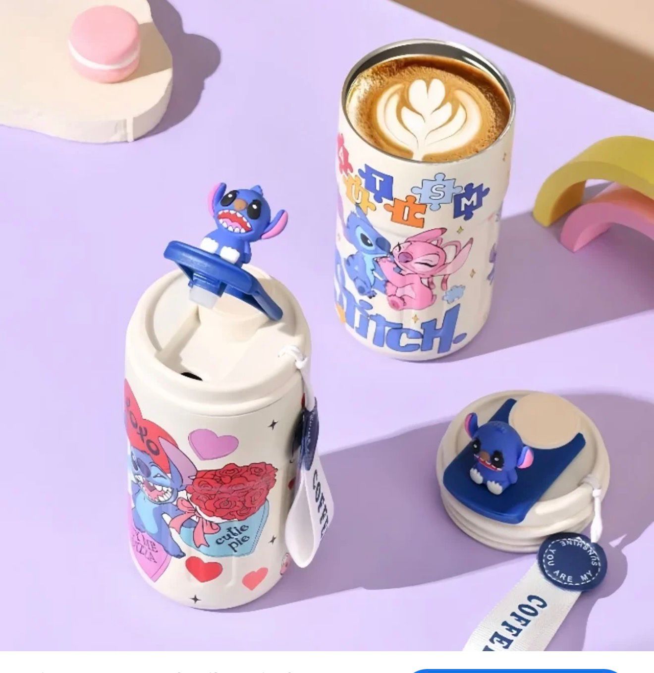 gourde isotherme blanc décoré de Stitch avec figurine 3D sur le couvercle, illustrations colorées et sangle, posé sur un fond pastel avec une tasse de café.