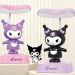 Deux lampes de bureau en forme de figurines Kuromi oscillantes sur des socles "Joyful Swing". À gauche, une version violette sur socle rose ; à droite, une version noire sur socle violet. Chaque figurine mesure 187 mm de hauteur et possède un abat-jour plat de couleur assortie au-dessus de sa tête.