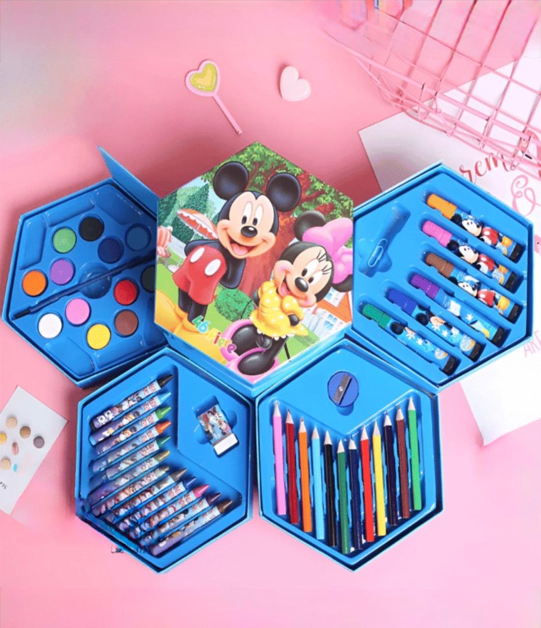 Coffret artistique hexagonal bleu à quatre niveaux ouvert sur un fond rose, décoré de Mickey et Minnie Mouse. Le kit contient 46 pièces incluant des crayons de couleur, des pastels à la cire, des feutres, des peintures à l'eau, un pinceau, une gomme et un taille-crayon