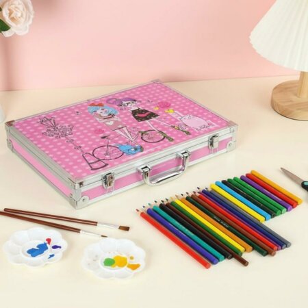 Coffret artistique en aluminium rose décoré d'illustrations de personnages, posé sur une table à côté d'une rangée de crayons de couleur, de pinceaux et de palettes de peinture