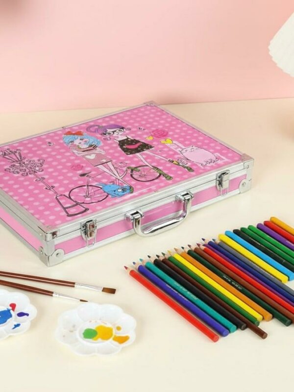 Coffret artistique en aluminium rose décoré d'illustrations de personnages, posé sur une table à côté d'une rangée de crayons de couleur, de pinceaux et de palettes de peinture