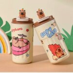 Deux bouteilles isothermes beiges illustrées de capybaras rigolos, avec une petite figurine de capybara en relief sur le couvercle.