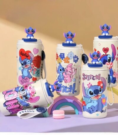 Gourdes blanches pour enfants décorées de Stitch avec figurine 3D sur le bouchon, illustrations colorées et sangle de transport, posées sur un décor pastel.