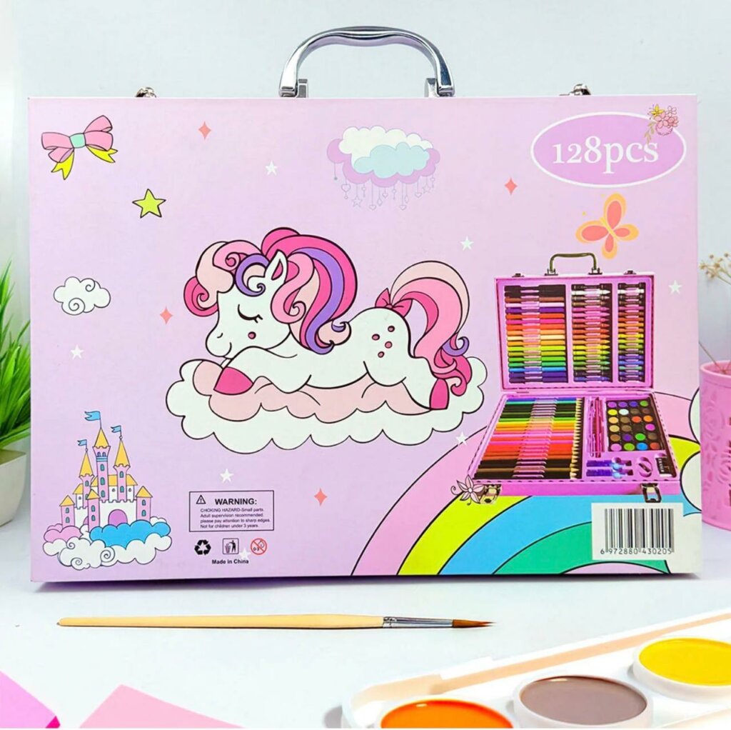 Emballage d'un kit de dessin rose illustrant une licorne couchée sur un nuage avec un arc-en-ciel et un château en arrière-plan. Le macaron "128pcs" est situé en haut à droite. Une vignette montre le coffret ouvert avec ses nombreux rangements de crayons et de peintures.