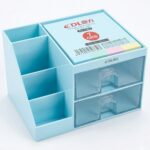 Organisateur de bureau en plastique bleu clair avec plusieurs compartiments ouverts et deux tiroirs transparents pour ranger stylos et accessoires