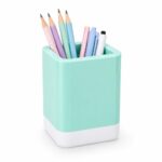 Pot à crayons carré aux angles arrondis, de couleur bleu menthe brillant avec une base blanche, contenant des crayons et des stylos de couleurs pastel sur un fond blanc uni.