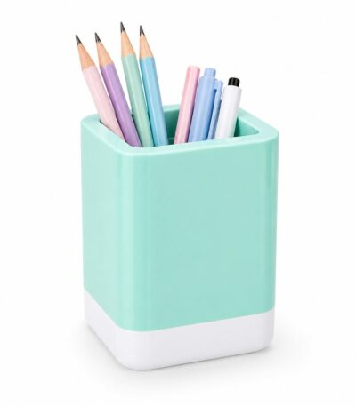 Pot à crayons carré aux angles arrondis, de couleur bleu menthe brillant avec une base blanche, contenant des crayons et des stylos de couleurs pastel sur un fond blanc uni.