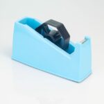 Dévidoir de ruban adhésif compact et robuste, disponible en rose, vert et bleu, doté d'une lame de coupe en acier et d'un noyau transparent.