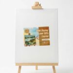 Mini chevalet d'exposition en bois clair supportant une toile blanche vierge de format 24x30 cm, avec une étiquette de présentation illustrée.