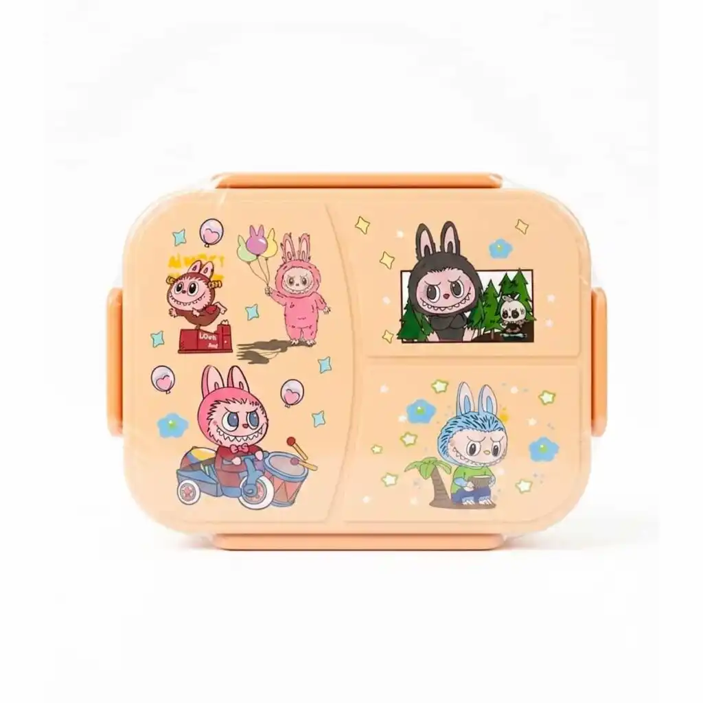 Une boîte à déjeuner (lunch box) pour enfant de couleur beige clair, encore sous emballage plastique transparent. Le couvercle est divisé visuellement en plusieurs zones décorées d'illustrations de style bande dessinée ou manga