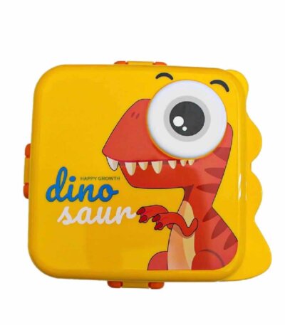 Une boîte à déjeuner (lunch box) rectangulaire de couleur jaune vif pour enfant. Sur le couvercle, on voit une illustration amusante d'un dinosaure rouge au style cartoon, avec un seul grand œil globuleux en relief sur la partie supérieure droite. À gauche du dinosaure, le mot "dino" est écrit en bleu cursif au-dessus du mot "saur" en blanc. L'inscription "HAPPY GROWTH" est notée en petits caractères au milieu. La boîte possède des attaches de fermeture orange sur les côtés et des motifs en forme de crêtes de dinosaure sur le bord droit.