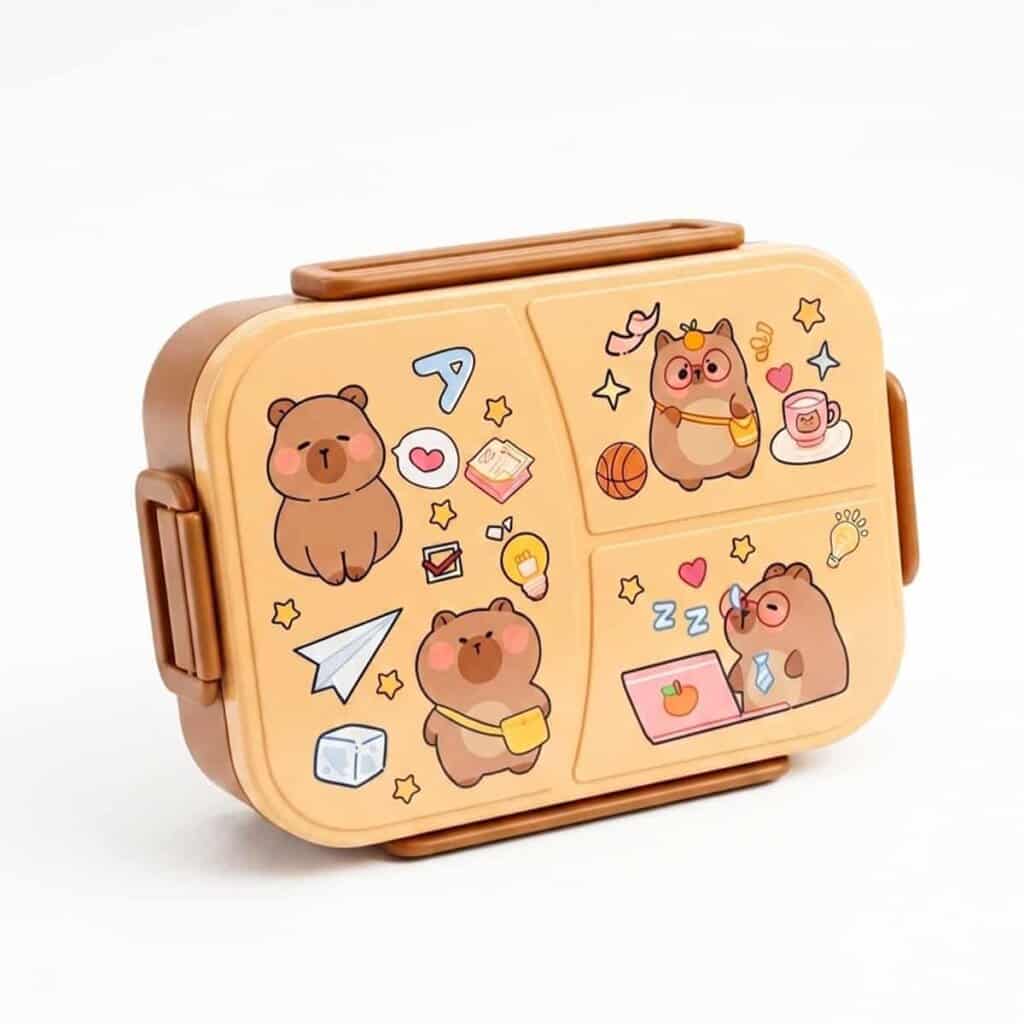 Une boîte à déjeuner (lunch box) pour enfant de couleur marron et beige clair, fermée par des clips latéraux. Le couvercle est décoré de jolies illustrations de style dessin animé représentant des petits ours bruns dans différentes situations : l'un est assis, un autre porte une sacoche, et un troisième avec des lunettes travaille sur un ordinateur portable rose. Le décor comprend également des petits motifs comme des étoiles, un ballon de basket et un avion en papier.