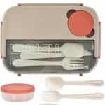 Une lunch box bento rectangulaire grège de 1300 ml, vue de dessus. Le couvercle supérieur intègre un compartiment transparent refermant un ensemble de trois couverts amovibles de couleur crème : une cuillère, une fourchette et un couteau cranté.