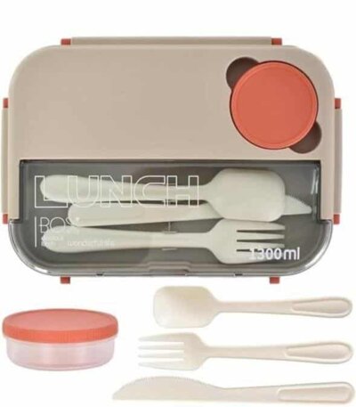 Une lunch box bento rectangulaire grège de 1300 ml, vue de dessus. Le couvercle supérieur intègre un compartiment transparent refermant un ensemble de trois couverts amovibles de couleur crème : une cuillère, une fourchette et un couteau cranté.