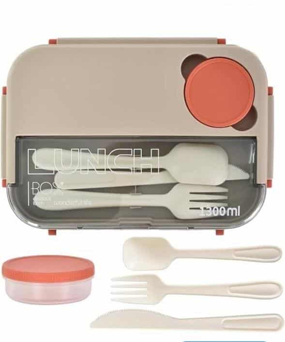 Une lunch box bento rectangulaire grège de 1300 ml, vue de dessus. Le couvercle supérieur intègre un compartiment transparent refermant un ensemble de trois couverts amovibles de couleur crème : une cuillère, une fourchette et un couteau cranté.