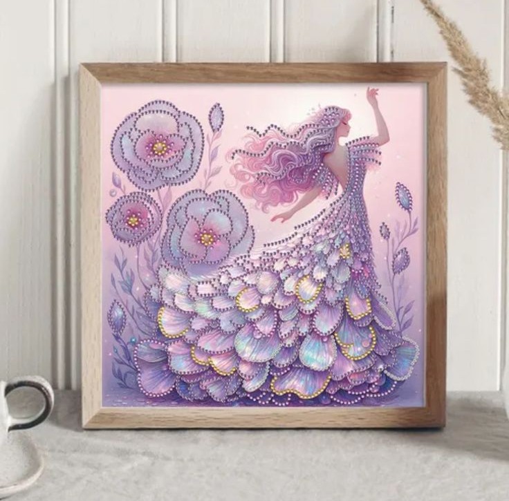 "Peinture Diamant Princesse de Cristal Violette à Plumes" Un tableau carré encadré de bois clair présente une broderie diamant dans les tons violets et lavande. Une femme élégante est représentée de profil, un bras levé, arborant de longs cheveux roses ondulés. Elle porte une robe de bal somptueuse et volumineuse, faite de strass scintillants superposés en forme de pétales ou de plumes aux reflets nacrés. Sur la gauche, de grandes fleurs violettes stylisées et ornées de perles brillantes complètent cette scène féerique.