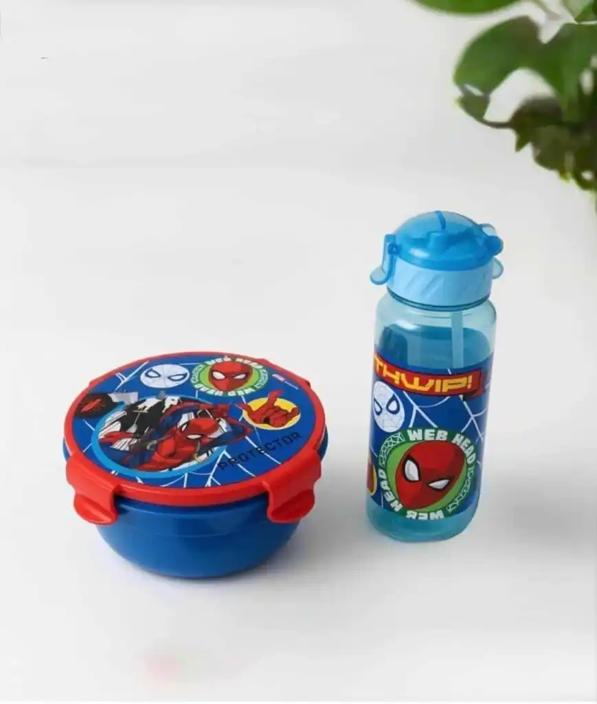 « Un ensemble de repas pour enfant sur le thème de Spider-Man, posé sur une surface blanche. Il comprend une boîte à déjeuner ronde de couleur bleue avec un couvercle rouge illustré par Spider-Man et Ghost-Spider, ainsi qu'une gourde bleue transparente assortie ornée du visage de Spider-Man