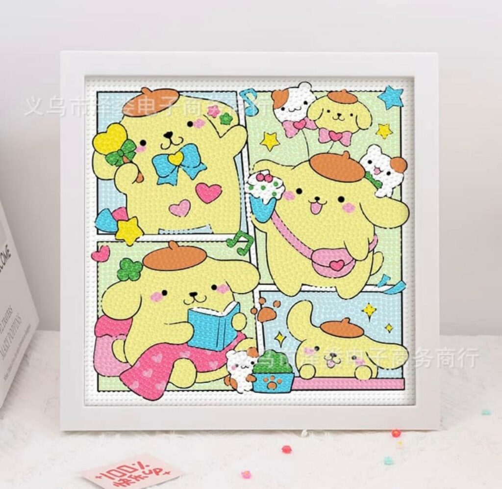 Tableau carré encadré de blanc affichant quatre scènes de style bande dessinée du personnage de Sanrio, Pompompurin. Le personnage, un chien jaune portant son célèbre béret marron, est représenté dans différentes attitudes mignonnes : lisant un livre, tenant un cornet de glace ou saluant joyeusement. L'illustration est entièrement réalisée en broderie diamant, créant une texture scintillante et en relief faite de petits strass colorés.