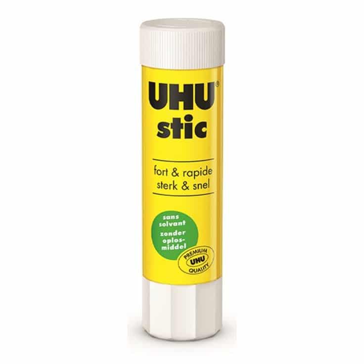 Bâton de colle UHU stic (8,2g / 21g / 40g) Un bâton de colle de la marque UHU présenté à la verticale sur un fond blanc uni. Le tube est principalement jaune vif, surmonté d'un bouchon à vis blanc et muni d'une molette rotative blanche à sa base. Le nom de la marque "UHU" et l'inscription "stic" sont imprimés en grandes lettres noires en haut du tube.