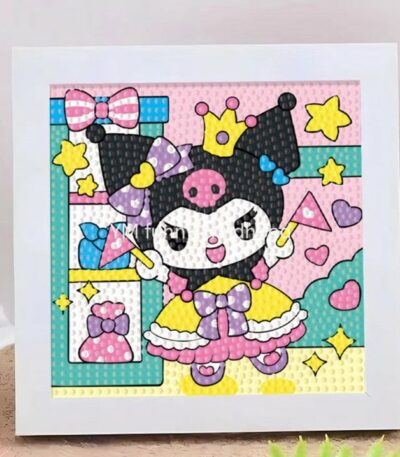 Un kit de broderie diamant terminé et encadré dans un cadre blanc carré posé sur une surface texturée. La toile montre le personnage Kuromi de Sanrio habillée en princesse. Elle porte sa coiffe noire à tête de mort rose surmontée d'une petite couronne jaune, une robe de bal jaune et rose avec un nœud papillon violet à pois blancs, et des chaussures violettes. Kuromi sourit, lève les bras et tient une baguette magique rose. À gauche, une étagère turquoise contient un nœud papillon rose, un flacon bleu et un parfum rose. L'arrière-plan est rose clair à pois blancs, décoré d'étoiles jaunes et de cœurs roses. Toute l'illustration est entièrement recouverte de strass ronds en relief qui donnent un effet texturé et brillant.