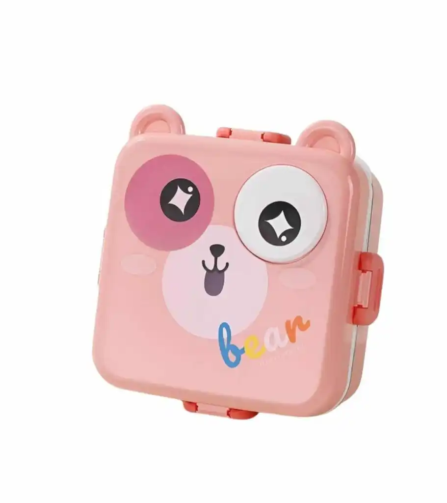 Une boîte à repas (lunch box) pour enfant de couleur rose pâle, en forme de tête d'ours stylisée. Le couvercle présente deux oreilles arrondies sur le dessus et un visage d'ours avec un œil rose, un œil blanc et un petit nez noir.