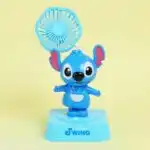 Mini ventilateur de bureau bleu en forme de Stitch avec une base marquée "Joyful Swing".