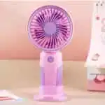 Mini ventilateur de bureau bicolore rose et violet sur son socle de table avec un bouton d'alimentation.