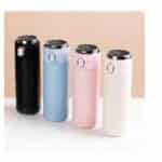 Alignement de quatre thermos intelligents aux couleurs pastel (noir, bleu, rose, blanc) avec affichage LED de la température sur le couvercle.
