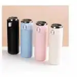 Alignement de quatre thermos intelligents aux couleurs pastel (noir, bleu, rose, blanc) avec affichage LED de la température sur le couvercle.