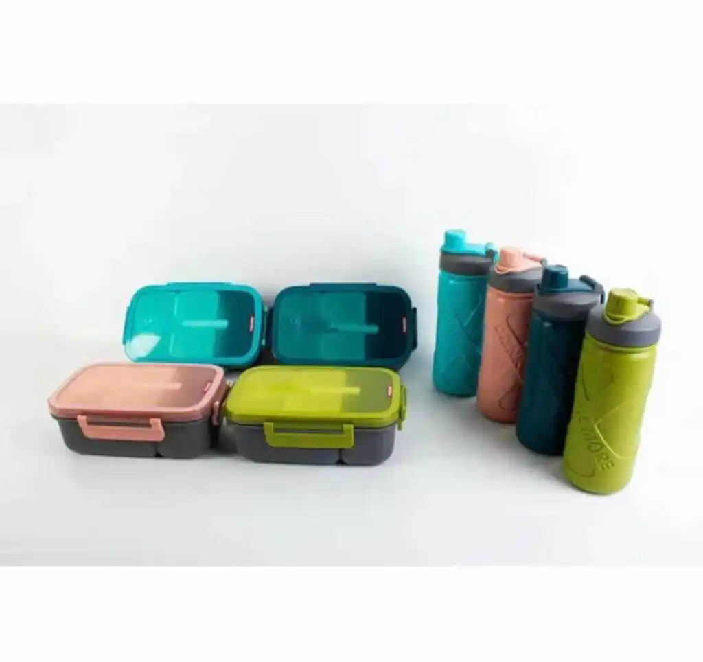 Une collection de quatre kits de repas coordonnés, disposés sur un fond blanc uni. À gauche, quatre boîtes à lunch rectangulaires à compartiments sont alignées sur deux rangées ; elles possèdent des couvercles translucides colorés (bleu turquoise, vert sapin, rose corail et vert olive) avec des clips de fermeture latéraux et une cuillère intégrée visible sur le dessus