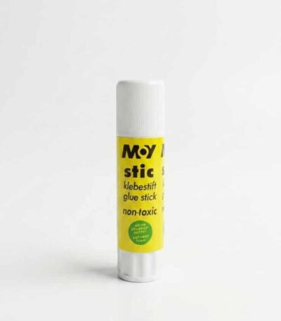 Un bâton de colle de la marque M•Y stic présenté à la verticale sur un fond blanc uni. Le tube possède un corps jaune vif habillé d'inscriptions noires, surmonté d'un bouchon cylindrique blanc et muni d'une molette rotative blanche à sa base. Le nom de la marque "M•Y stic" est imprimé en lettres noires épaisses en haut du tube.
