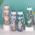 Quatre gourdes transparentes pour enfants et adolescents illustrées avec le personnage Labubu de Pop Mart. Les bouteilles se déclinent en rose, violet, bleu clair et vert d'eau, disposant d'un bouchon à clapet blanc avec un anneau de transport intégré.