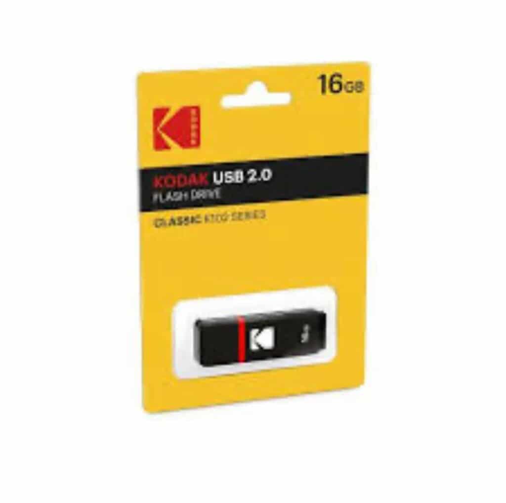 Une clé USB 2.0 de marque Kodak, modèle Classic K102, présentée dans son emballage en carton d'origine de couleur jaune vif. Le coin supérieur droit de l'emballage affiche distinctement la capacité de « 16 GB ». La clé USB elle-même, de couleur noire avec une fine bande rouge et le logo blanc de Kodak, est visible sous une coque en plastique transparent dans la partie inférieure du paquet.