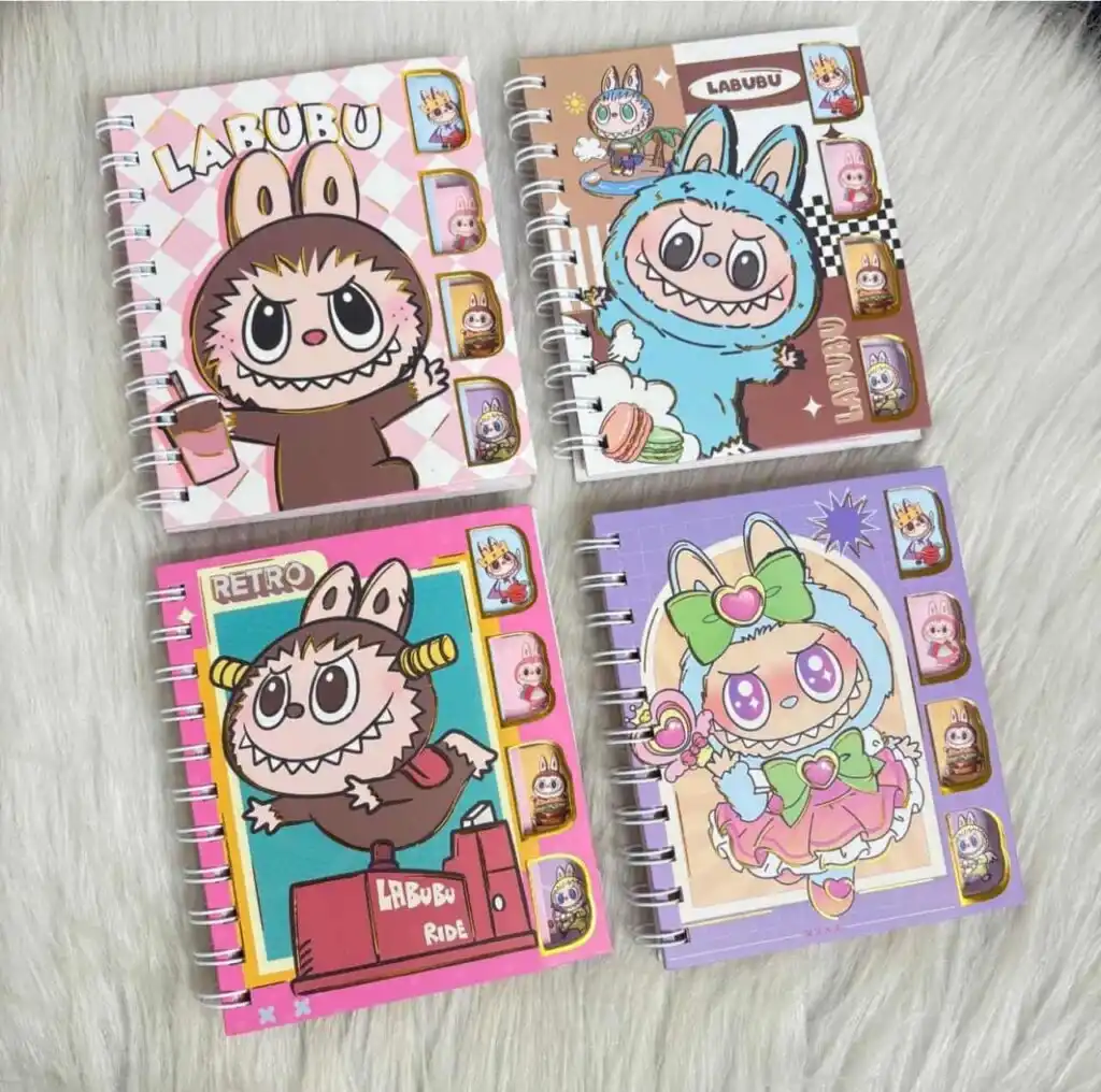 Quatre carnets de notes à spirales métalliques blanches de la collection Labubu et The Monsters, disposés sur une fourrure blanche synthétique. Les couvertures en carton rigide se déclinent en rose pastel à damier, marron chocolat, rose fuchsia rétro et violet magique.