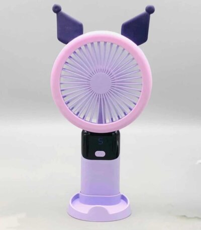 Un mini ventilateur portable rechargeable de couleur violette et mauve, inspiré du personnage Kuromi de Sanrio, posé verticalement sur son socle de table assorti. La tête ronde possède une grille rose-mauve surmontée de deux oreilles pointues de bouffon violet foncé. Le manche intègre un écran numérique noir affichant le chiffre « 5 » en bleu juste au-dessus d'un bouton d'alimentation blanc.