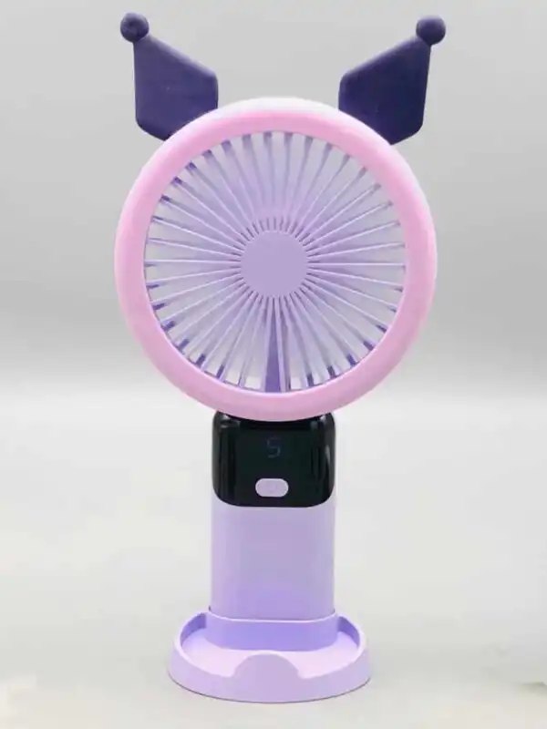 Un mini ventilateur portable rechargeable de couleur violette et mauve, inspiré du personnage Kuromi de Sanrio, posé verticalement sur son socle de table assorti. La tête ronde possède une grille rose-mauve surmontée de deux oreilles pointues de bouffon violet foncé. Le manche intègre un écran numérique noir affichant le chiffre « 5 » en bleu juste au-dessus d'un bouton d'alimentation blanc.