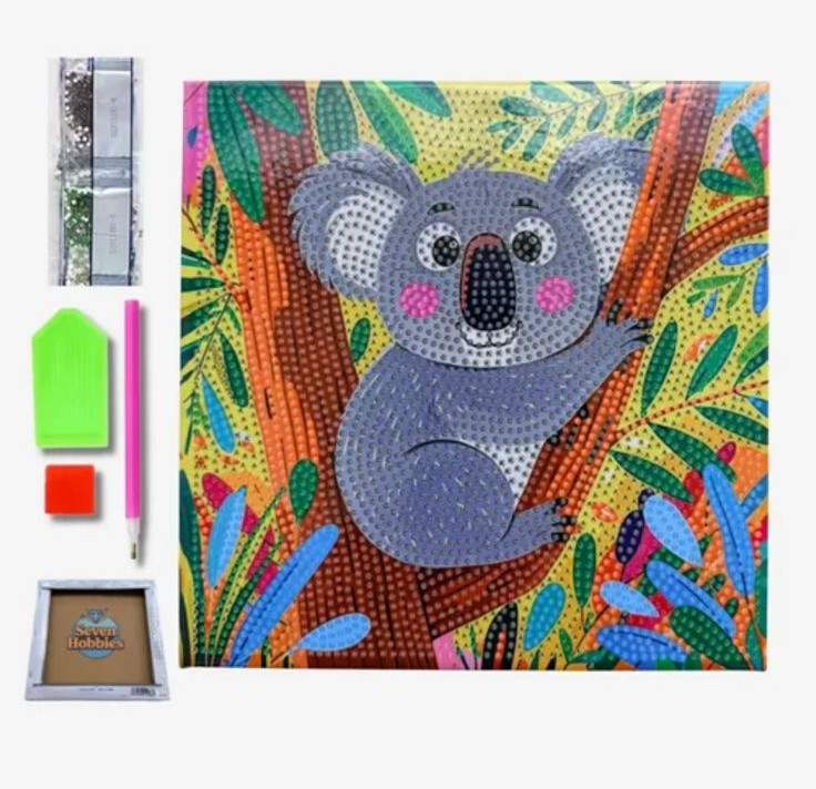 Un kit complet de broderie diamant pour enfants présenté sur fond blanc. La toile carrée au centre montre une illustration colorée et enfantine d'un koala gris assis sur la branche d'un arbre. Le koala a de grands yeux ronds, des joues roses et un grand nez noir. Il est entouré de feuilles tropicales stylisées vertes, jaunes, rouges et bleues. Toute la surface du dessin est recouverte de petits cercles pour guider la pose des strass. À gauche de la toile se trouvent les accessoires inclus : une rangée verticale de sachets de diamants colorés, un plateau de tri vert, un carré de cire rouge, un stylet applicateur rose et, tout en bas, un petit cadre de présentation en bois de la marque "Seven Hobbies".